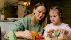 respite worker playing blocks with a disabled girl